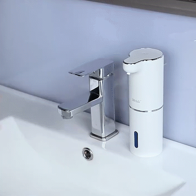 White soap dispenser on a marble countertop with a blue wall in the background
