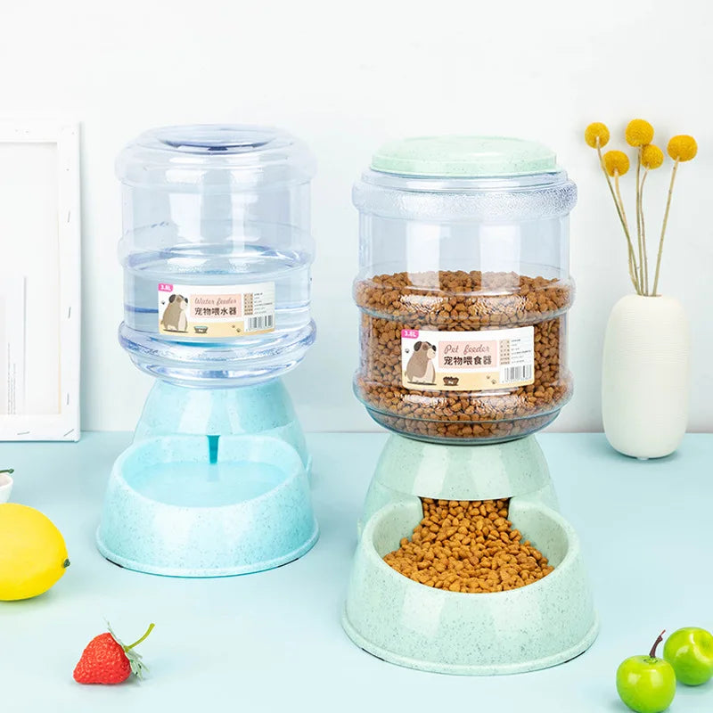 Pet water bottle and food dispenser on a light blue surface with fruits and a vase in the background.