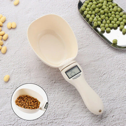 Digital measuring scoop with a digital display on a light gray surface with food items around.