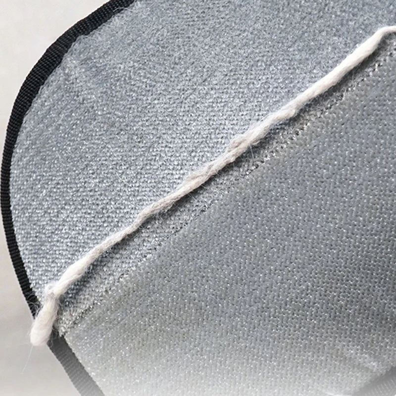 Close-up of a textured gray fabric with a black border on a light gray background