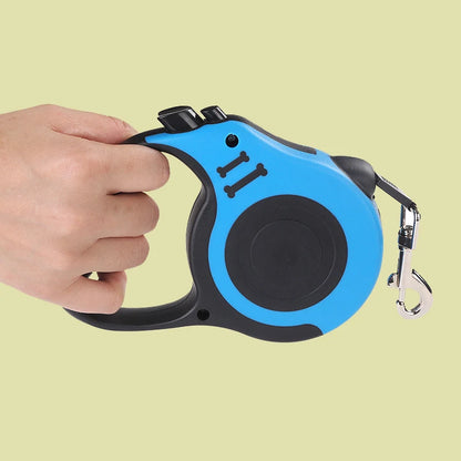 Hand holding a blue and black retractable dog leash against a light green background
