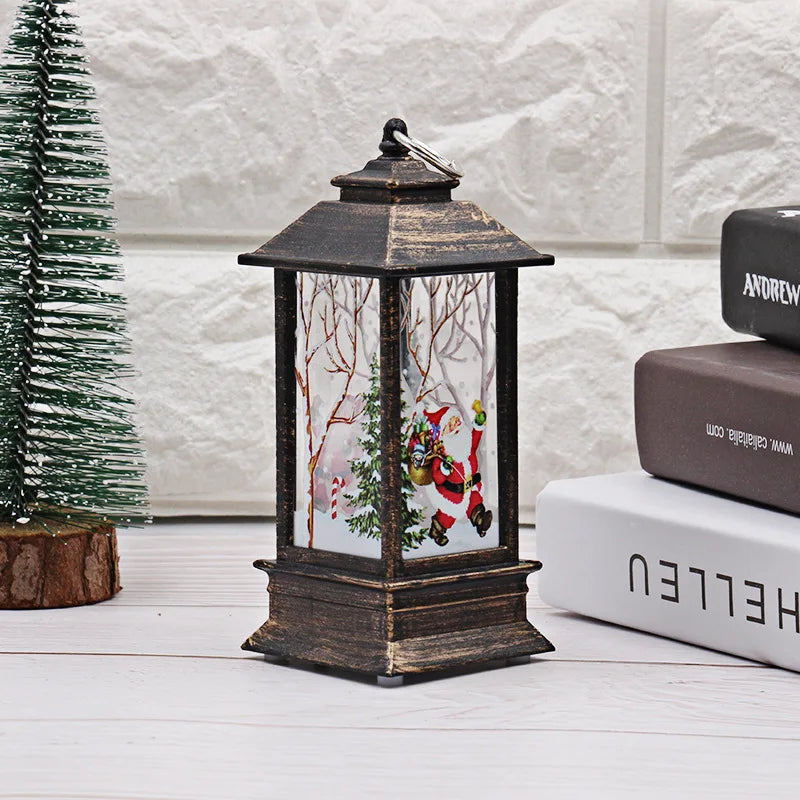 Decorative lantern with a Santa Claus design on a white surface with books and a small tree.